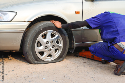 Photo: Flat tire on car with technician Flat tire on car with technician