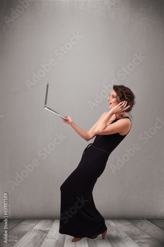 Photo: Young woman holding modern laptot Young woman holding modern laptot