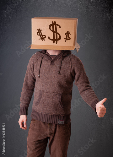 Photo: Young man gesturing with a cardboard box on his head with dollar Young man gesturing with a cardboard box on his head with dollar