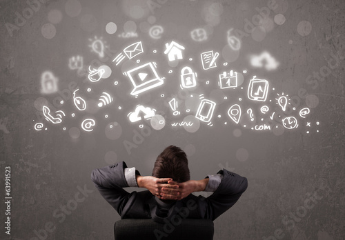 Photo: Business man looking at modern icons and symbols Business man looking at modern icons and symbols