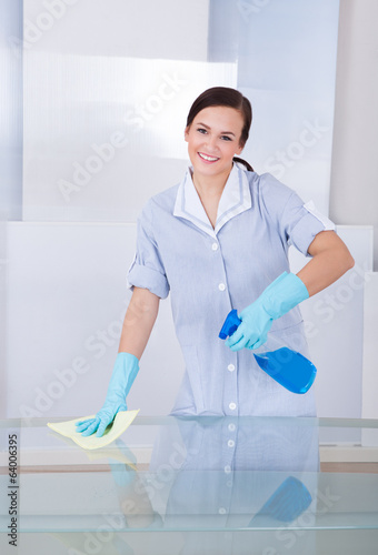 Photo: Happy Maid Cleaning Glass Table Happy Maid Cleaning Glass Table