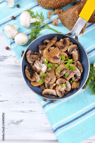 Photo: Delicious fried mushrooms in pan on table close-up Delicious fried mushrooms in pan on table close-up