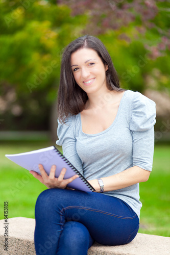 Photo: Young beautiful female student reading a book Young beautiful female student reading a book