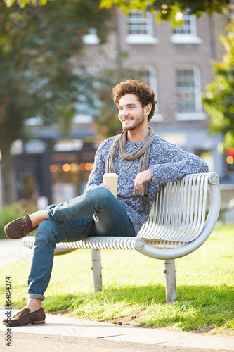Photo: Man Relaxing On Park Bench With Takeaway Coffee Man Relaxing On Park Bench With Takeaway Coffee