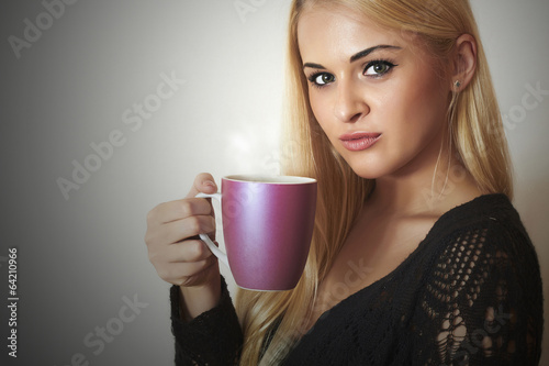Photo: Happy Beautiful woman drinking Coffee.Blond Girl with Cup of tea Happy Beautiful woman drinking Coffee.Blond Girl with Cup of tea