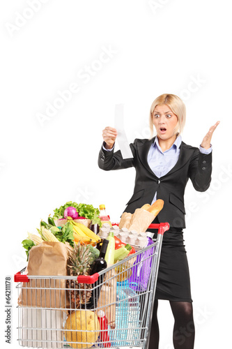 Photo: Formal woman looking at the shopping bill in disbelief Formal woman looking at the shopping bill in disbelief
