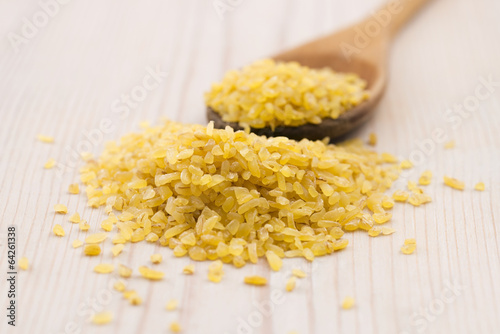 Photo: bulgur wheat in wooden spoon bulgur wheat in wooden spoon