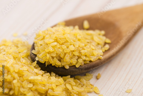 Photo: bulgur wheat in wooden spoon bulgur wheat in wooden spoon