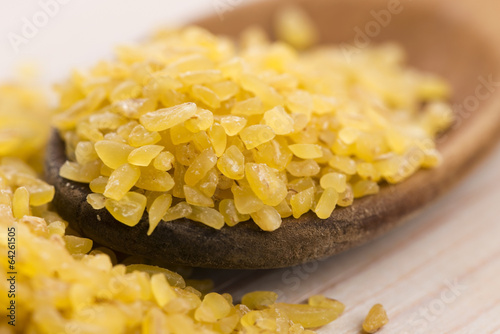 Photo: bulgur wheat in wooden spoon bulgur wheat in wooden spoon