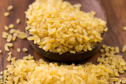 Photo: bulgur wheat in wooden spoon bulgur wheat in wooden spoon