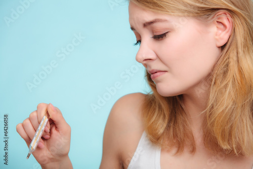 Photo: Flu. Sick girl with fever checking thermometer. Flu. Sick girl with fever checking thermometer.