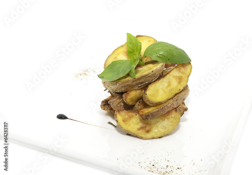 Photo: Baked potatoes on a plate decorated with greens Baked potatoes on a plate decorated with greens
