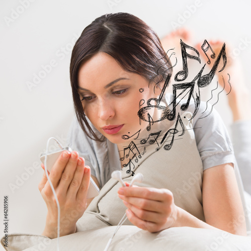 Photo: Woman listening music smartphone Woman listening music smartphone