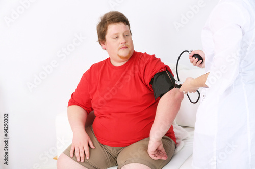 Photo: Doctor examining patient obesity on light background Doctor examining patient obesity on light background