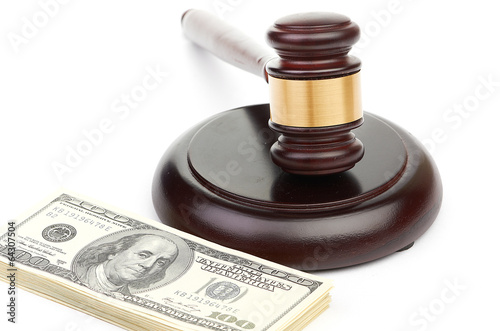 Photo: Law gavel on a stack of American money. Law gavel on a stack of American money.