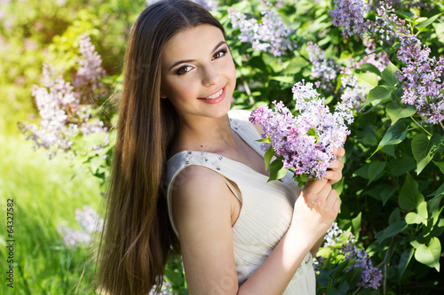Photo: Beautiful girl with a lilac flowers Beautiful girl with a lilac flowers