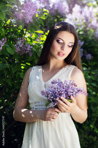 Photo: Beautiful girl with a lilac flowers Beautiful girl with a lilac flowers