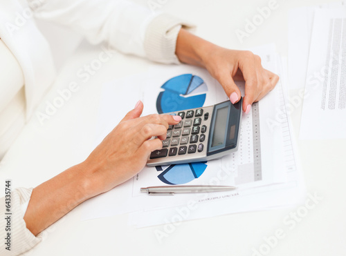 Photo: businesswoman working with calculator in office businesswoman working with calculator in office