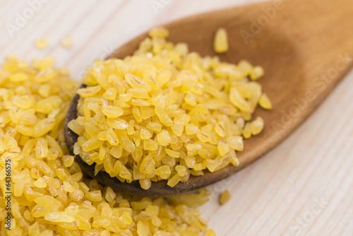 Photo: bulgur wheat in wooden spoon bulgur wheat in wooden spoon