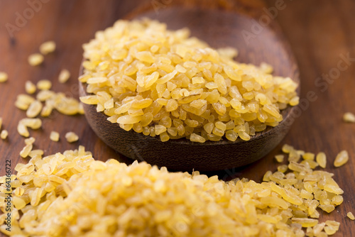 Photo: bulgur wheat in wooden spoon bulgur wheat in wooden spoon