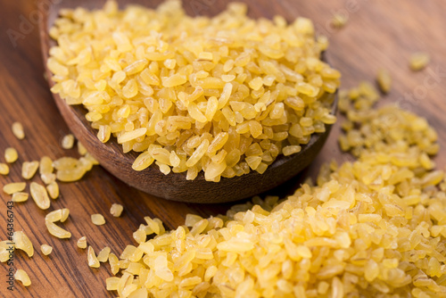 Photo: bulgur wheat in wooden spoon bulgur wheat in wooden spoon