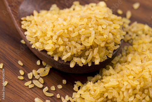 Photo: bulgur wheat in wooden spoon bulgur wheat in wooden spoon