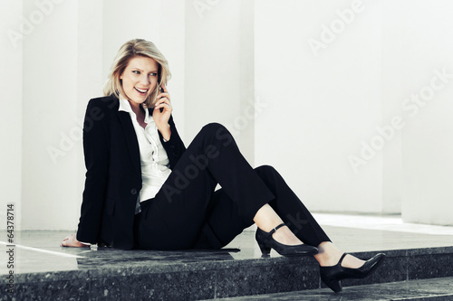Photo: Young business woman calling on the cell phone Young business woman calling on the cell phone