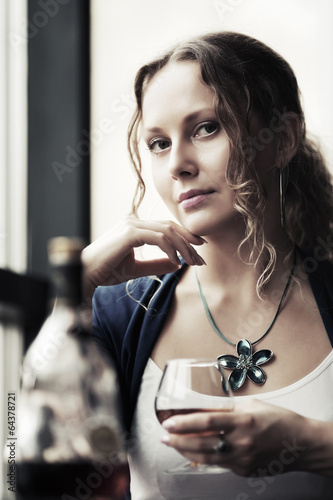 Photo: Sad beautiful woman drinking cognac at restaurant Sad beautiful woman drinking cognac at restaurant