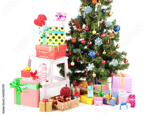 Photo: Decorated Christmas tree with gifts isolated on white Decorated Christmas tree with gifts isolated on white