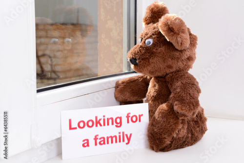 Photo: Toy-bear looking out window close-up Toy-bear looking out window close-up