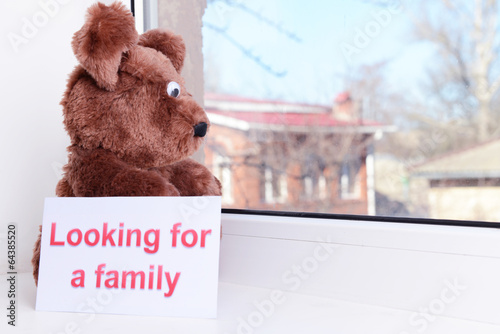 Photo: Toy-bear looking out window close-up Toy-bear looking out window close-up