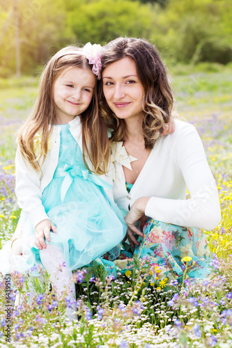 Photo: Mother and daughter in field with colorful flowers Mother and daughter in field with colorful flowers