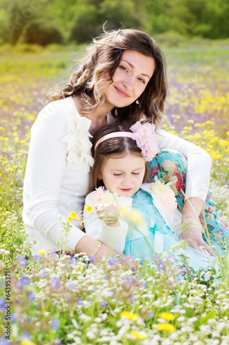 Photo: Mother and daughter in field with colorful flowers Mother and daughter in field with colorful flowers
