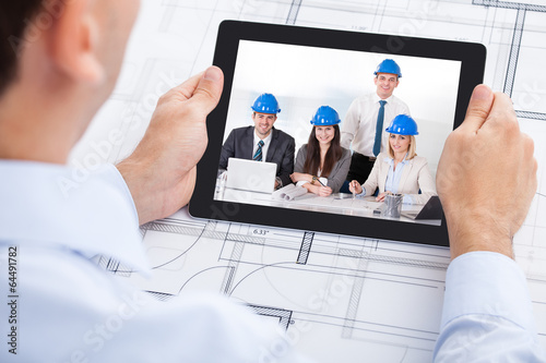 Photo: Architect Video Conferencing With Team Through Digital Tablet Architect Video Conferencing With Team Through Digital Tablet