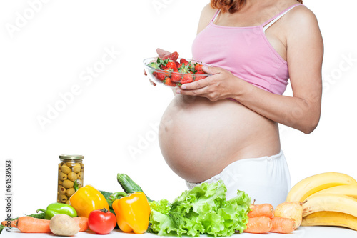 Photo: pregnant woman belly with vegetables and fruits pregnant woman belly with vegetables and fruits
