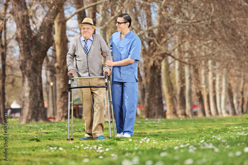 Photo: Medical professional helping a senior in park Medical professional helping a senior in park