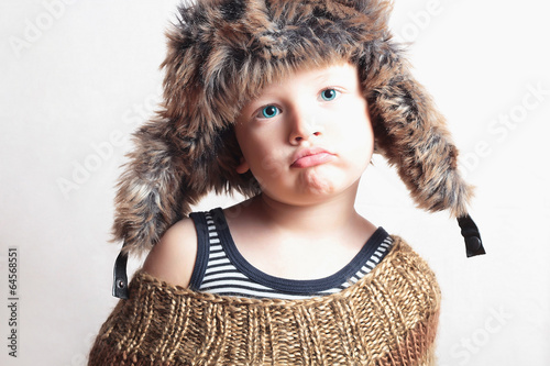 Photo: child in fur Hat.fashion winter style.little funny boy child in fur Hat.fashion winter style.little funny boy