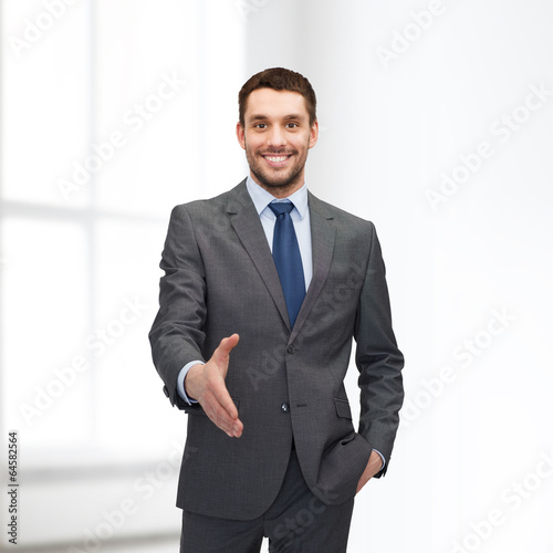 Photo: businessman with open hand ready for handshake businessman with open hand ready for handshake