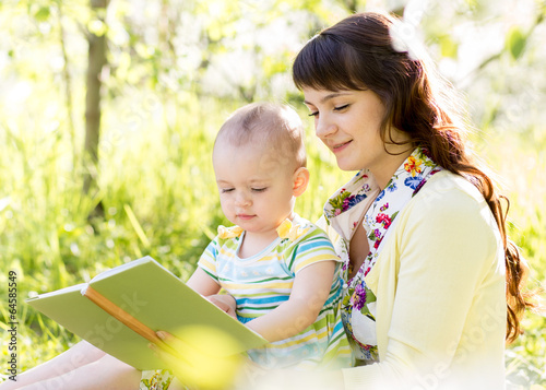Photo: happy mother reading a book to child outdoors happy mother reading a book to child outdoors