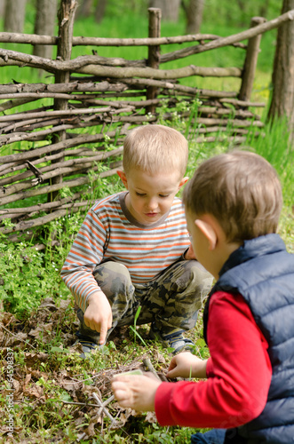 Photo: Two young boys discussing lighting a campfire Two young boys discussing lighting a campfire