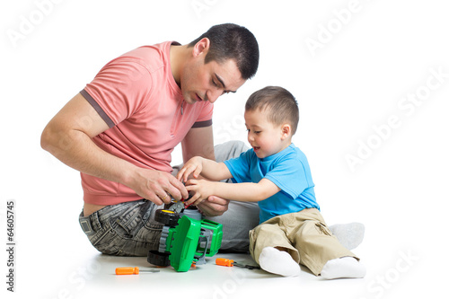 Photo: kid boy and his father repair toy car kid boy and his father repair toy car