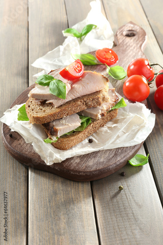 Photo: Delicious sandwiches with meet on table close-up Delicious sandwiches with meet on table close-up