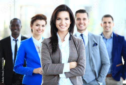Photo: happy young female business leader standing in front of her team happy young female business leader standing in front of her team