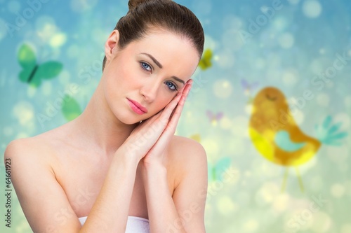 Photo: Composite image of beautiful brunette with hands at face Composite image of beautiful brunette with hands at face
