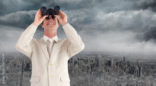 Photo: Composite image of confident businessman with binoculars Composite image of confident businessman with binoculars