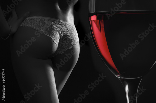 Beautiful silhouette of a female body and a glass of red wine