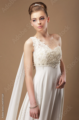 Photo: Femininity. Gentle Woman in Lacy Dress over Beige Background Femininity. Gentle Woman in Lacy Dress over Beige Background