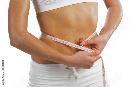 Photo: young athletic woman measuring waist young athletic woman measuring waist