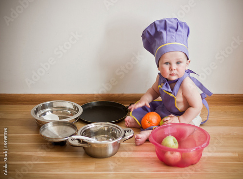 Photo: Little boy in a chief hat sitting on a floor Little boy in a chief hat sitting on a floor