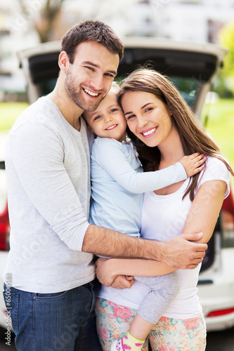 Photo: Happy family with car on background Happy family with car on background